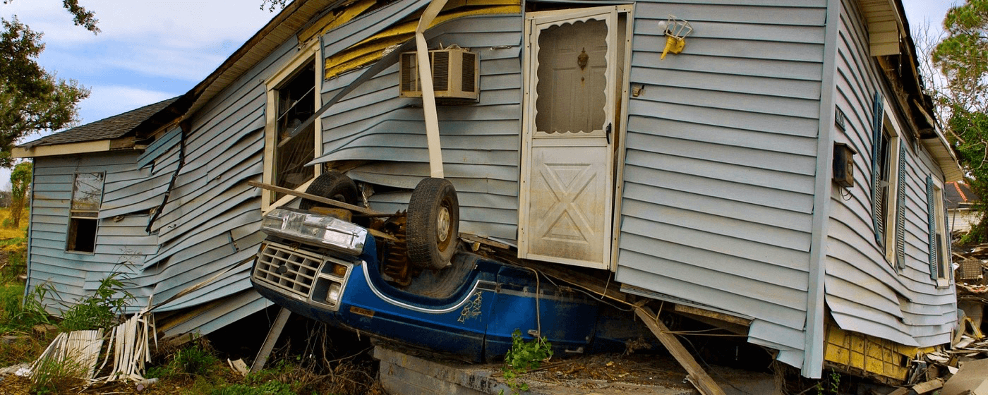 House damaged by strong hurricane with turned over truck