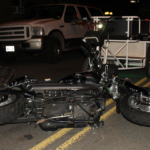 motorcycle accident close up on a road at night with a car behind